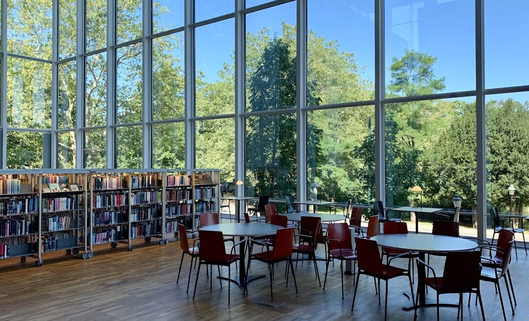 Modern European library with floor-to-ceiling windows and rolling bookshelves, representing the study environment for Indian scholars in Germany, Ireland, and the Netherlands in 2026